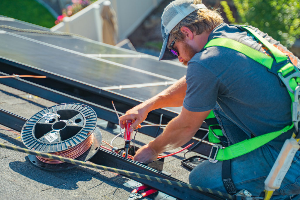 Man installing solar panels on roof