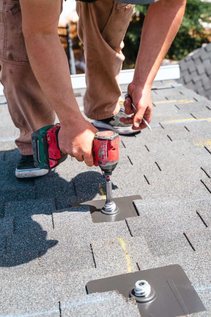 Person installing roofing materials with tools
