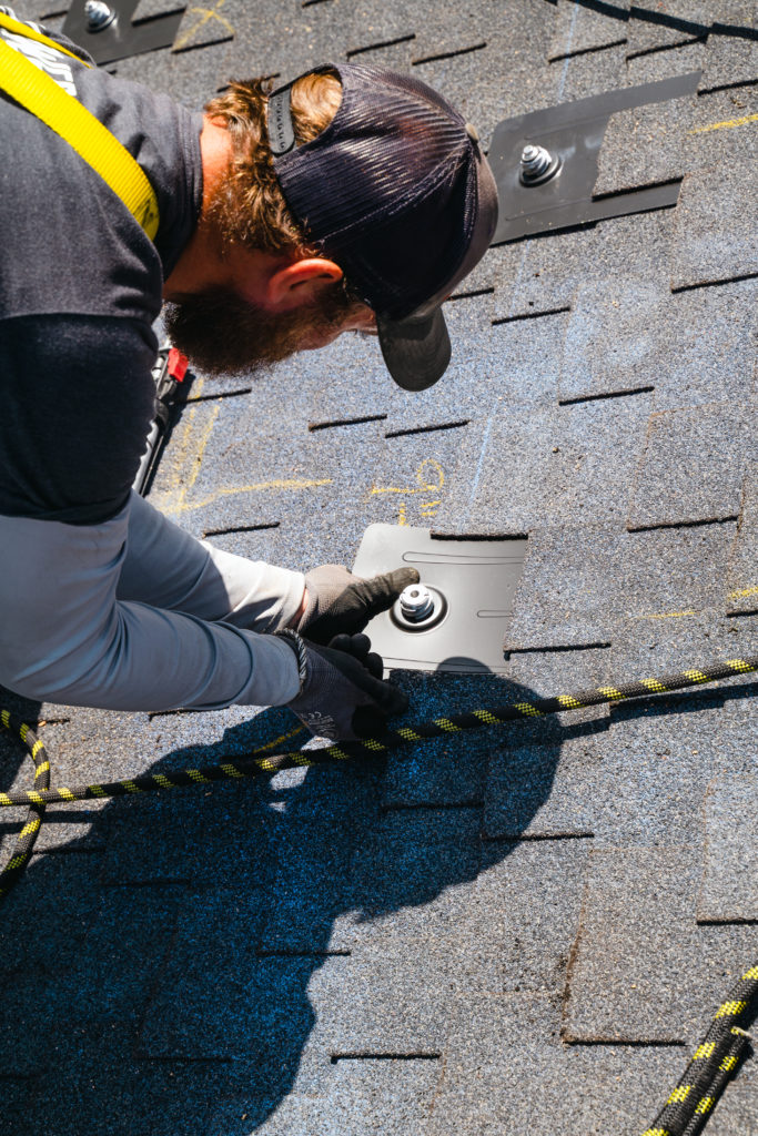 Worker installing roofing materials on roof