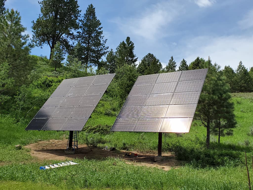 Pole mount solar in grass next to trees