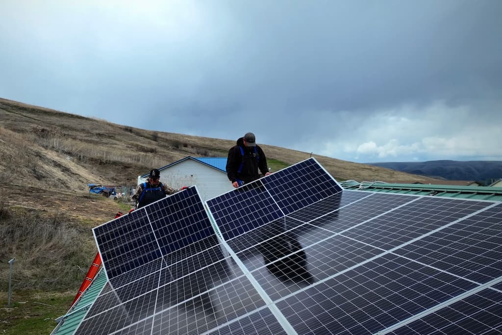 two people installing roof top solar panels